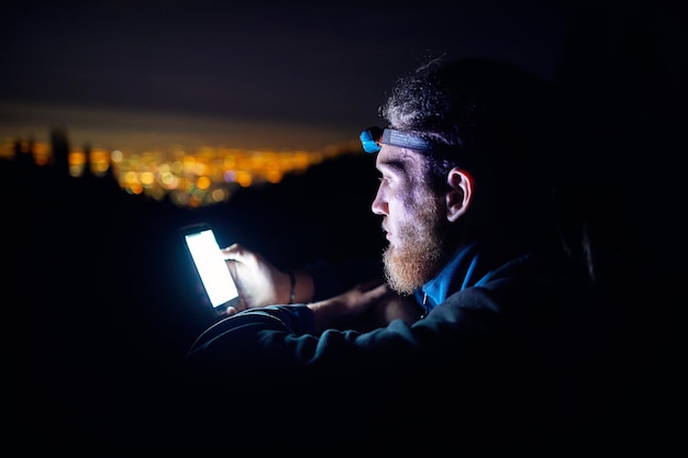 Mann mit Telefon am Nachthimmel