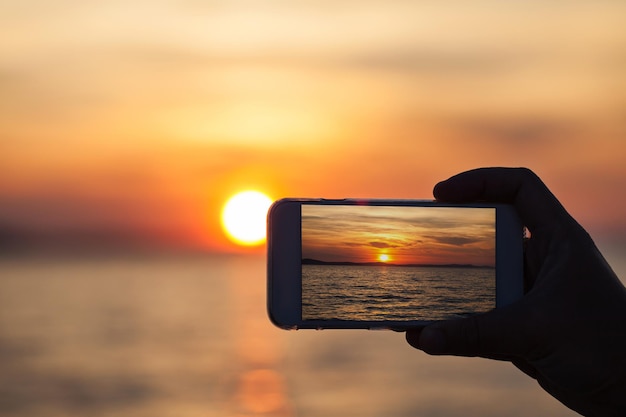 Mann mit Telefon am Strand