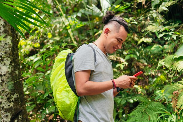 Mann mit Telefon im tropischen Wald
