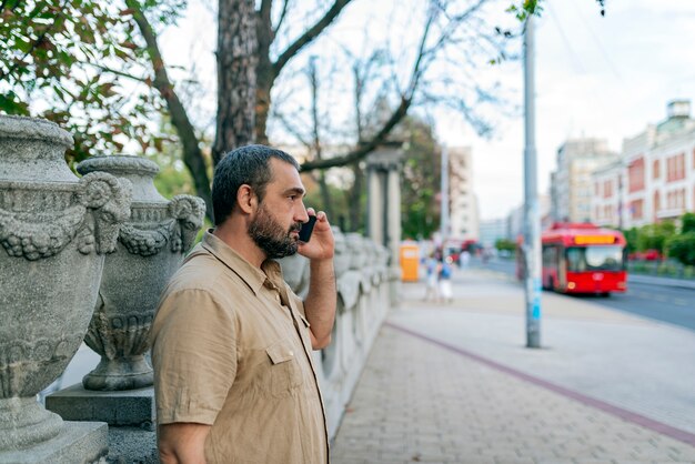 Mann mit Telefon in der Stadtstraße