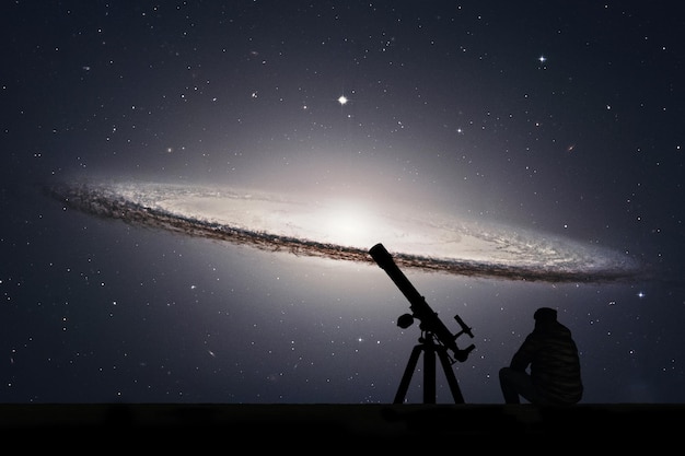 Foto mann mit teleskop blickt auf die sterne sombrero galaxy m104