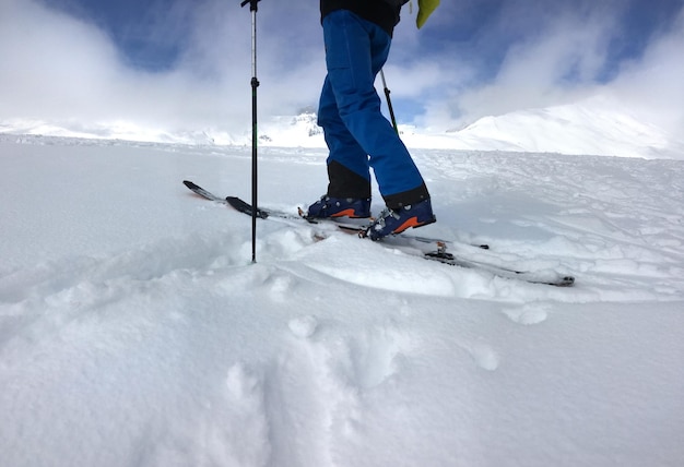 Mann mit Tourenski-Kletterberg im Neuschnee