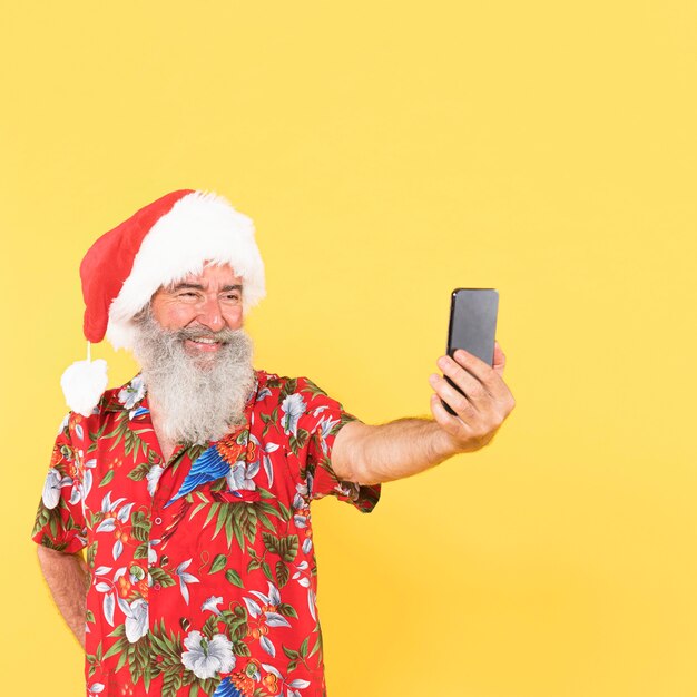 Foto mann mit tropischem hemd und weihnachtsmütze mit kopienraum