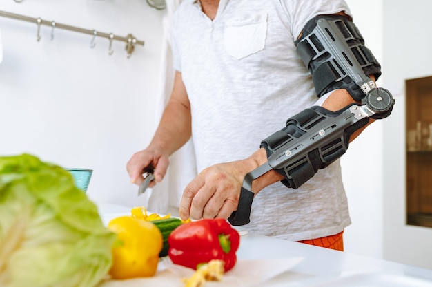 Mann mit verletzter Hand bereitet Salat zu