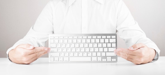 Mann mit weißer Tastatur des Computers oder des Laptops