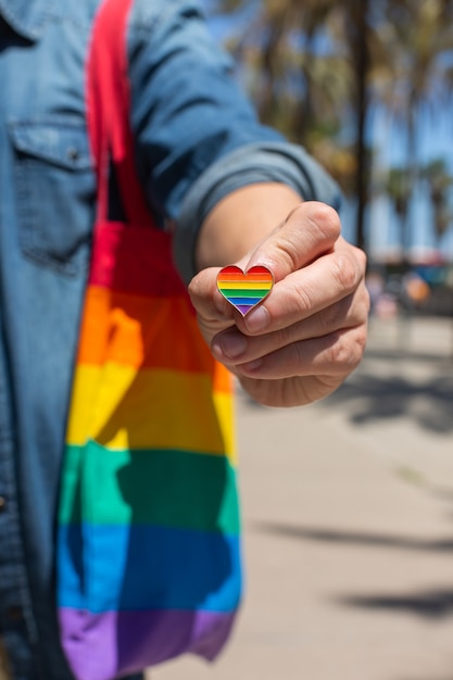 Mann mit wiederverwendbarer Regenbogentasche und LGBT-Abzeichen Stolzmonat