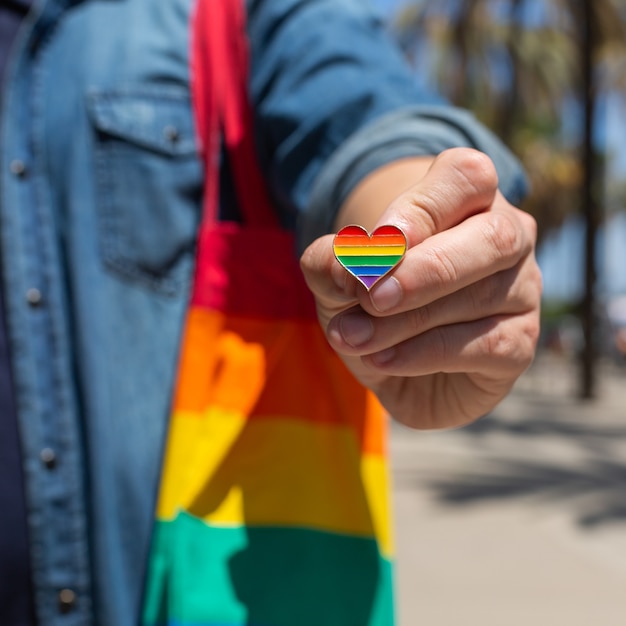 Mann mit wiederverwendbarer Regenbogentasche und LGBT-Abzeichen Stolzmonat