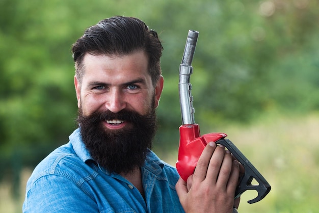 Mann mit Zapfpistole Kraftstoffpumpe Tankstelle Tankstelle Benzin oder Benzin wird gepumpt g