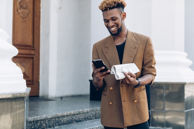 Mann mit Zeitung mit Smartphone