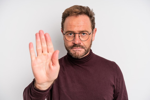 Mann mittleren Alters, der ernsthaft aussieht und eine offene Handfläche zeigt, die eine Stoppgeste macht