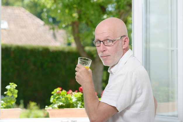 Mann mittleren Alters ein Getränk Orangensaft
