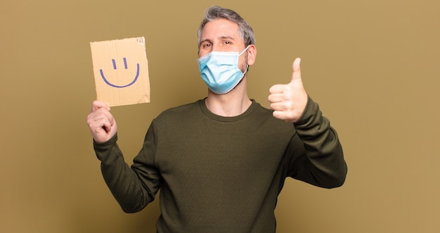 Mann mittleren Alters mit medizinischer Maske und Haltebrett mit Smiley