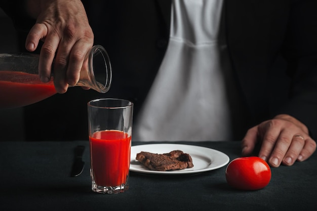 Mann nimmt Essen aus Steak und Tomatensaft