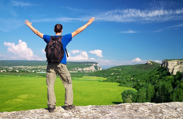 Mann oben auf dem Berg. Tourismuskonzept. Tourist auf dem hohen Felsen.