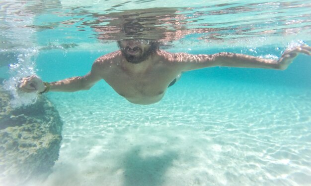 Mann ohne Hemd schwimmt im Meer