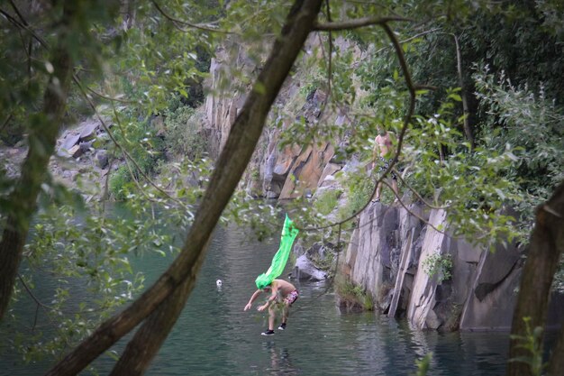 Foto mann ohne hemd taucht in den fluss