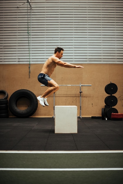 Foto mann ohne hemd trainiert im fitnessstudio