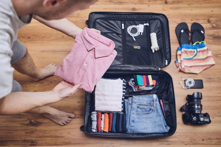 Foto mann packt kleidung zu hause in das gepäck