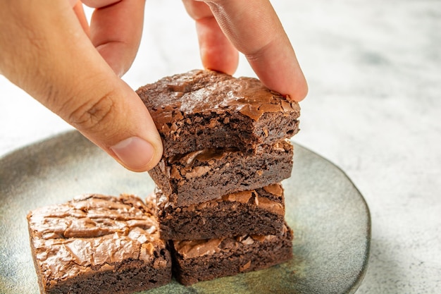 Mann pflückt köstliche Brownies auf einem hausgemachten Gourmet-Teller