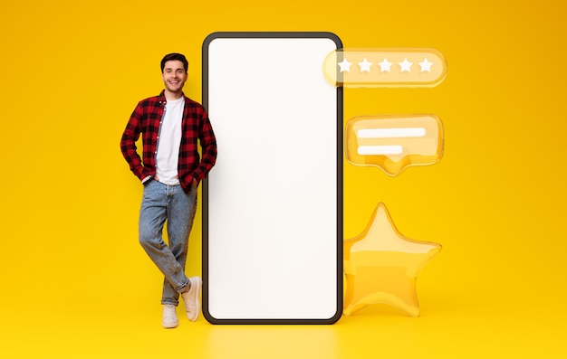 Mann posiert in der Nähe von Smartphone und Sternsymbolen auf gelbem Hintergrund