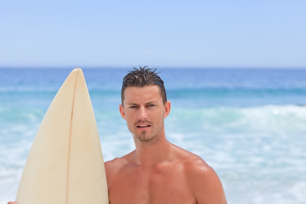 Mann posiert mit seinem Surfbrett