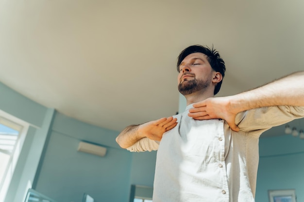 Foto mann praktiziert yoga, junger, attraktiver mann tut atemübungen, mann meditiert zu hause an der durin.