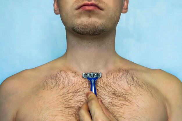 Mann rasiert seine Brust mit Rasiermesser Nahaufnahme des Körpers