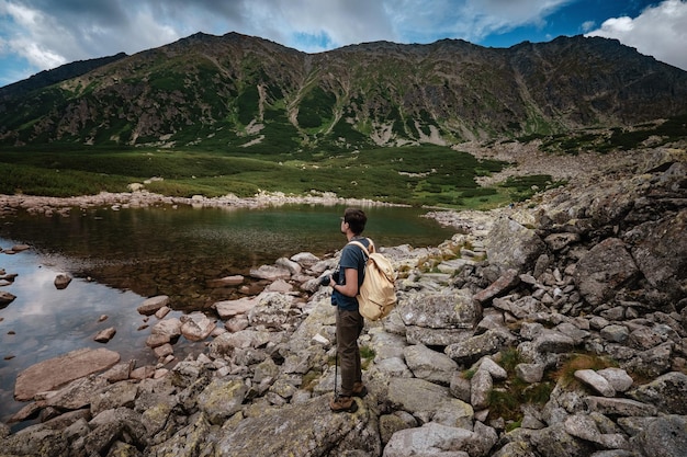 Mann Reisender mit Rucksack in der Nähe von Bergsee Reise-Lifestyle-Konzept Reise- und aktives Lebenskonzept mit Team Abenteuer und Reisen in der Bergregion in der polnischen Tatri