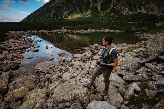 Mann Reisender mit Rucksack in der Nähe von Bergsee Reise-Lifestyle-Konzept Reise- und aktives Lebenskonzept mit Team Abenteuer und Reisen in der Bergregion in der polnischen Tatri