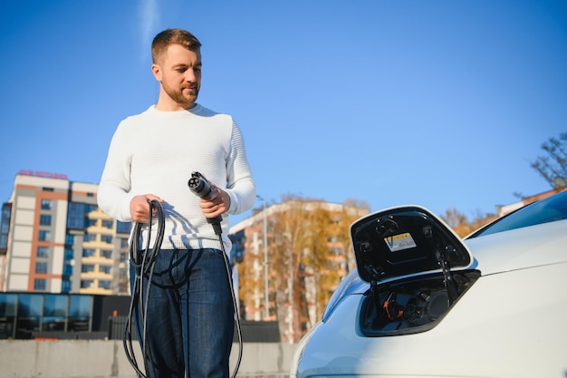 Mann schaltet das Aufladen des Autos ein