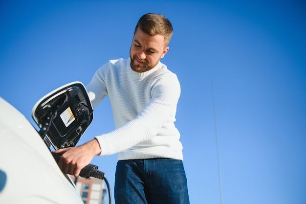 Mann schaltet das Aufladen des Autos ein