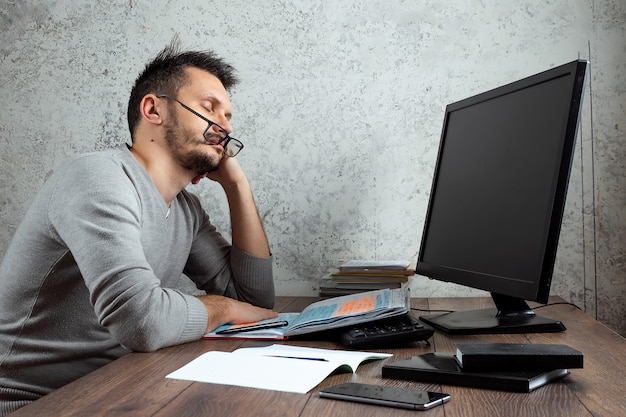 Mann schläft an einem Tisch im Büro.