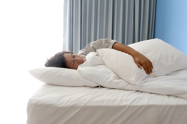 Mann schläft auf dem Bett im Hotelzimmer