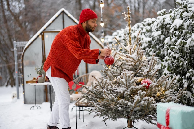 Mann schmückt Weihnachtsbaum im Hinterhof