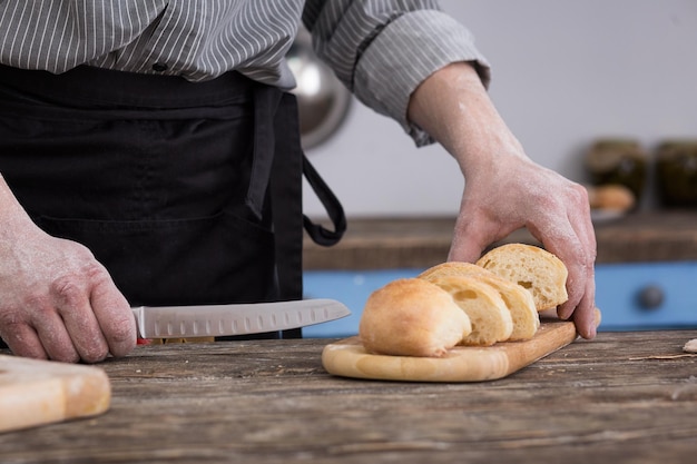 Mann schneidet Brot in der Küche