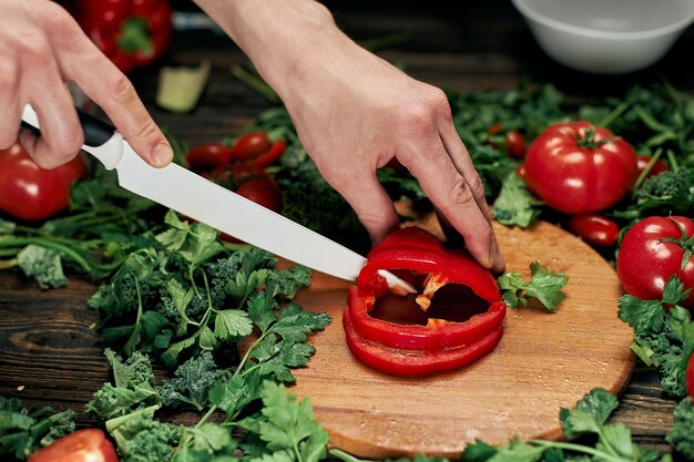 Mann schneidet Paprika auf dem Küchentisch