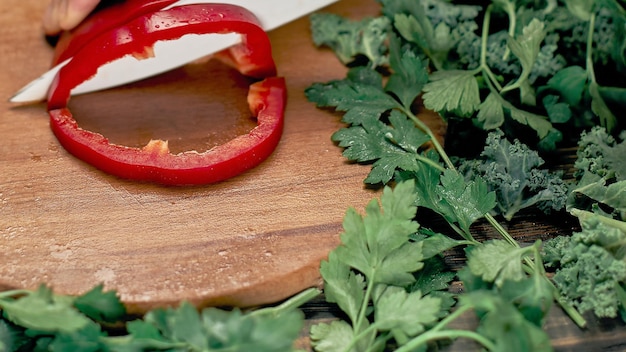 Mann schneidet Paprika auf dem Küchentisch