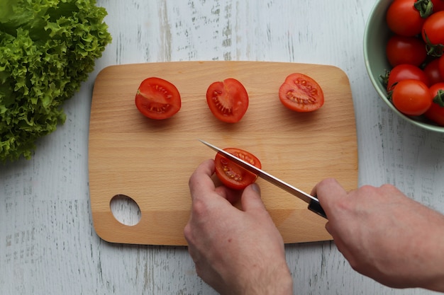 Foto mann schneidet tomaten auf salat