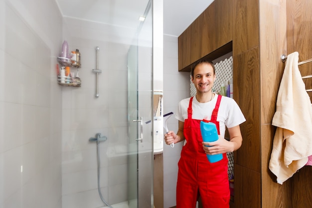 Foto mann schrubbt eine graue duschwand im badezimmer