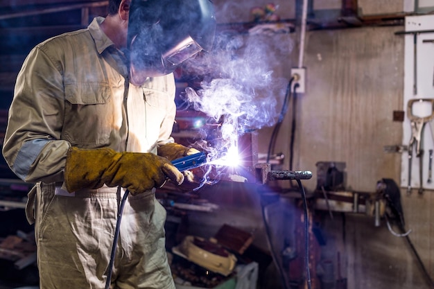 Mann schweißt Metall in der Werkstatt