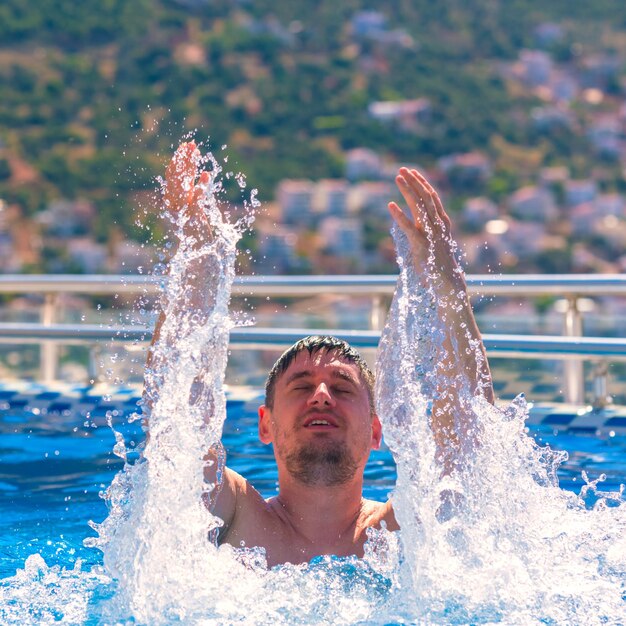 Mann schwimmt im Pool mit Spritzern