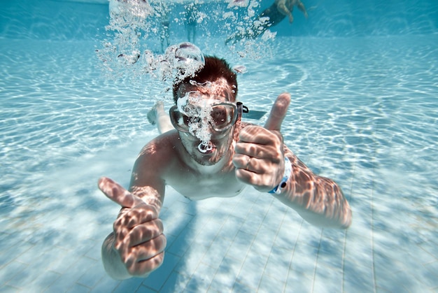 Mann schwimmt unter Wasser im Pool