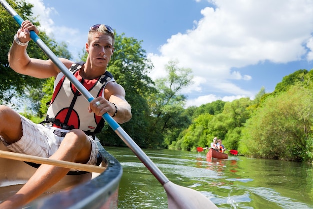 Mann segelt mit dem Boot im See gegen den Himmel