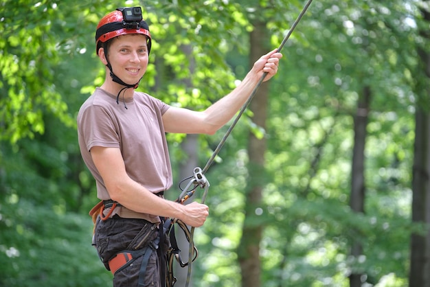 Mann sichert seinen Partnerbergsteiger mit Sicherungsgerät und Seil. Der Handmann des Kletterers, der Ausrüstung für die Sicherheit des Felsenbergsteigens hält.