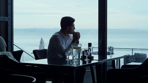 Mann Silhouette mit wunderschönem Meerblick entspannendes Luxus-Panorama-Restaurant