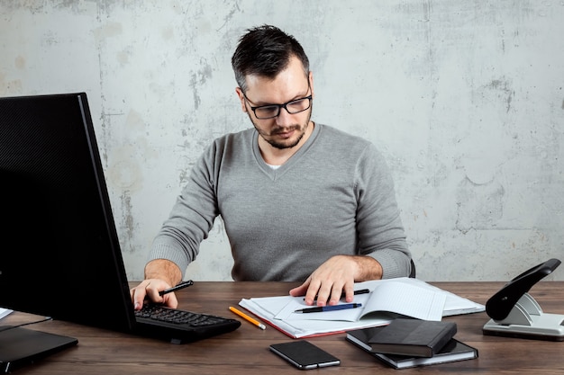 Mann sitzt an einem Tisch im Büro