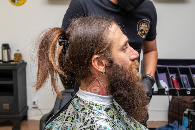 Mann sitzt im Friseurstuhl.