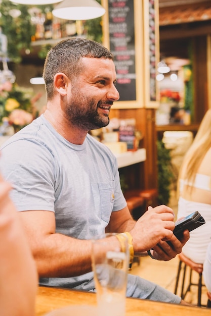 Mann sitzt in einer Bar und hat eine gute Zeit.