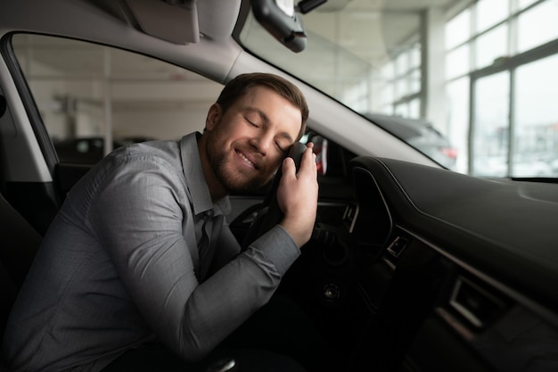 Mann sitzt in seinem schönen Auto