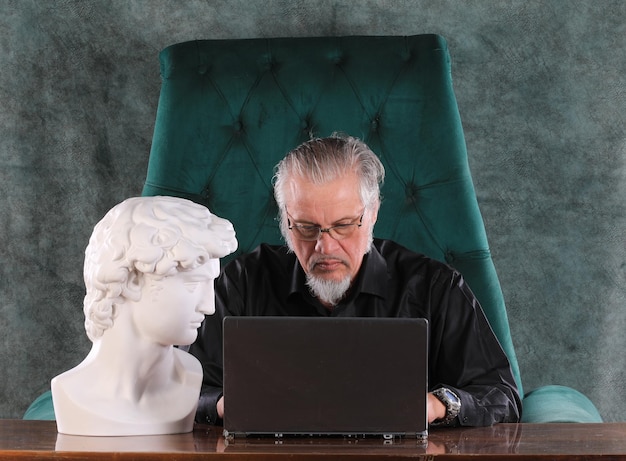 Mann sitzt nachts mit Laptop